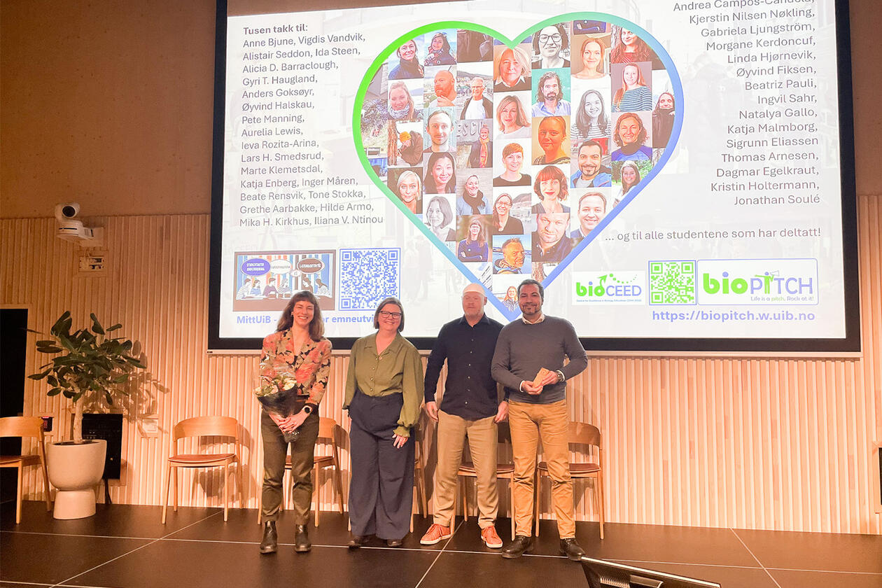 Dagmar Egelkraut, Kristin Holtermann, Øyvind Halskau and Jonathan Soulé receive the UiB Owl Award for quality in education for the Student Poster Symposium on behalf of bioCEED and the Department of Biological Sciences. The photo shows the team gathered in front of a large screen displaying a heart-shaped collage of portrait pictures of all the persons involved in the Student Poster Symposium.